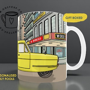 May include: White ceramic mug with a yellow three-wheeled vehicle design set against a city scene. The mug features the text "HOOKY STREET" and "& HORSES". It is labeled "GIFT BOXED" and "PERSONALISED ONLY FOOLS".