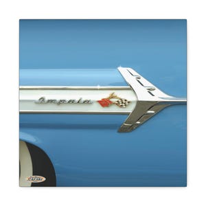 May include: A light blue car fender featuring a chrome trim piece with the script text Impala and a gold and red checkered emblem. A metallic silver fin-shaped accent extends horizontally across the side panel, reflecting light on its surface.