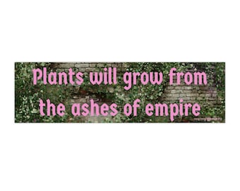 May include: A green and brown brick wall with vines growing over it. The text "Plants will grow from the ashes of empire" is written in pink letters on the wall.