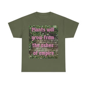 May include: Olive green t-shirt with the text "Plants will grow from the ashes of empire" in pink letters. The text is superimposed on a graphic of a brick wall covered in green plants.