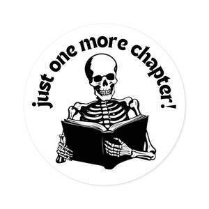 May include: A black and white illustration of a skeleton reading a book with the text "just one more chapter!" around the outside of the circle.