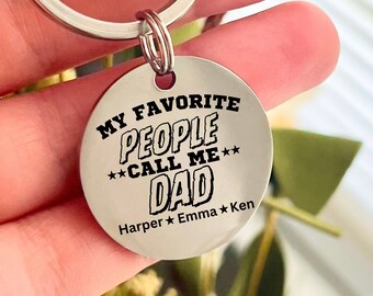 May include: Silver keychain with a round tag that says "My Favorite People Call Me Dad" with the names Harper, Emma, and Ken underneath.