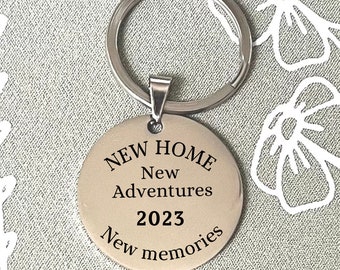 May include: Silver keychain with a round tag that says "NEW HOME New Adventures 2023 New memories".