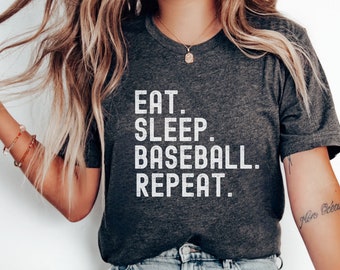 May include: A dark grey t-shirt with the text "EAT. SLEEP. BASEBALL. REPEAT." printed in white.