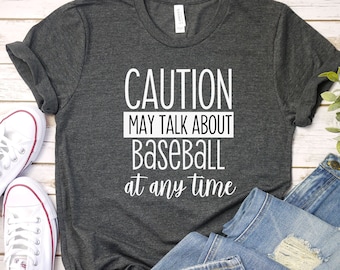 May include: A dark gray t-shirt with white text that reads "CAUTION MAY TALK ABOUT BASEBALL at any time".