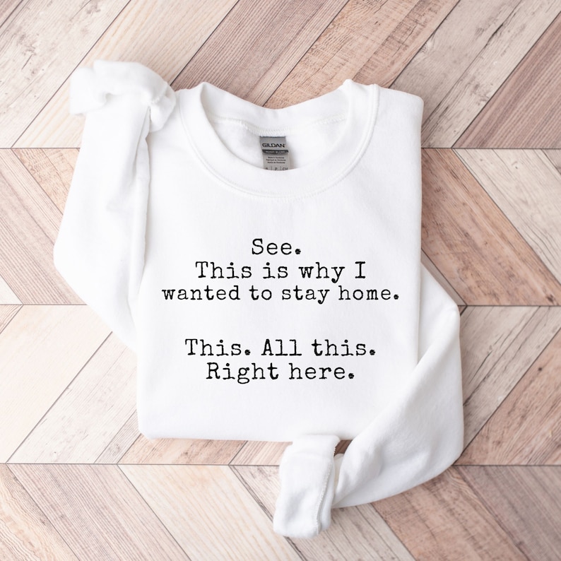 May include: White sweatshirt with the text "See. This is why I wanted to stay home. This. All this. Right here." printed in black.