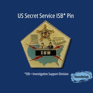 May include: A US Secret Service ISB pin. The pin is pentagon-shaped with a gold border and features a gold star, a computer, and two figures. The pin also includes a map of the United States and the letters "ISD".