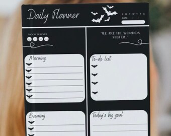May include: A black and white daily planner with a Halloween theme. The planner has sections for morning, evening, to-do list, today's big goal, and a water tracker. The planner also includes a mood tracker and a space for the date.