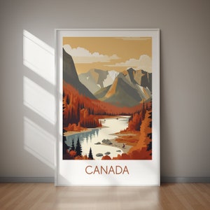 May include: A framed art print featuring a stylized landscape of Canada. The artwork depicts a river winding through a valley with mountains in the background. The color palette includes shades of orange, brown, and blue. The word "CANADA" is printed at the bottom.