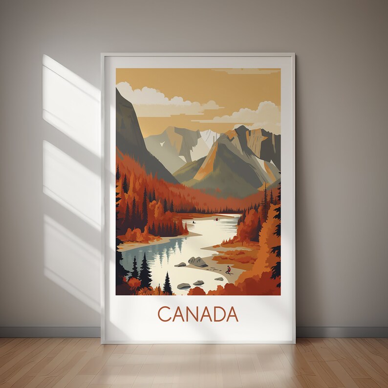 May include: A framed art print featuring a stylized landscape of Canada. The artwork depicts a river winding through a valley with mountains in the background. The color palette includes shades of orange, brown, and blue. The word "CANADA" is printed at the bottom.