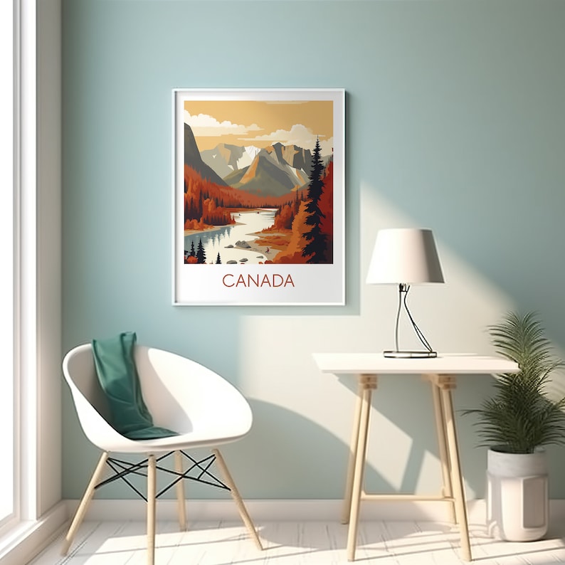 May include: A framed art print featuring a stylized landscape of Canada. The artwork depicts mountains, a river, and autumn-colored trees under a warm, orange sky. The word "CANADA" is printed in brown at the bottom.