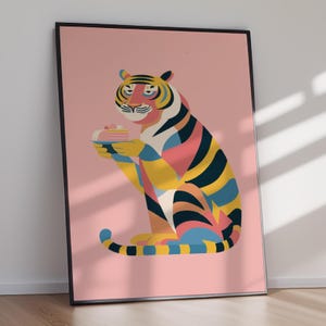 Könnte beinhalten: Ein gerahmter Kunstdruck mit einem stilisierten Tiger, dessen Fell mit gelben, blauen, rosafarbenen und schwarzen Streifen gemustert ist. Der Tiger sitzt und hält einen kleinen Teller mit einem geschichteten Kuchenstück vor einem hellrosa Hintergrund.