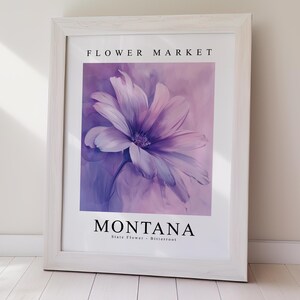 May include: A framed print featuring a purple flower against a light purple background. The text "FLOWER MARKET" is at the top and "MONTANA State Flower - Bitterroot" is at the bottom.