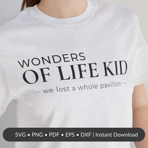 以下が含まれることがあります： 「WONDERS OF LIFE KID」の黒い文字と「- we lost a whole pavilion -」のフレーズがプリントされた、ライトグレーのTシャツ。下部にはファイルの種類オプションを示す黒いバーがあります。
