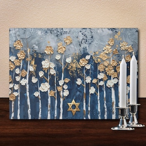 May include: An abstract painting with gold and white floral accents against a blue and gray textured background. A gold Star of David is centered on the painting. Two white candles stand in silver candle holders.