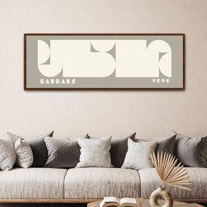 May include: A framed print with a geometric design in white on a light gray background. The print reads "BAUHAUS 1919".