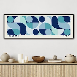 May include: A framed print with a geometric design in shades of blue and green. The print features abstract shapes and circles, with the text "BAUHAUS 1919" at the bottom.