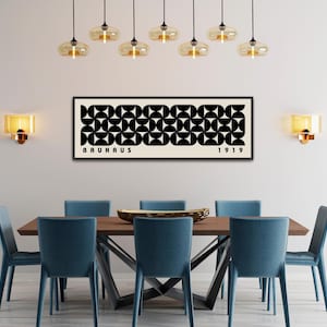 May include: A dining room featuring a rectangular wooden table with eight teal chairs. Above the table hangs a framed Bauhaus art print with a black and white geometric design. The room is illuminated by pendant lights and wall sconces.