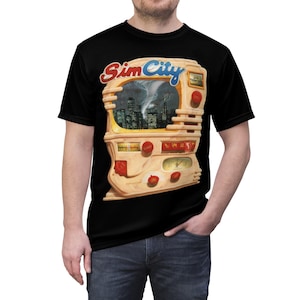 May include: A black t-shirt with a graphic of a retro-style television screen with the words "SimCity" printed above it. The screen shows a city skyline with a tornado in the background.