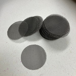 May include: A stack of round, silver-colored metal mesh filters. The filters are about 2 inches in diameter and have a fine mesh.