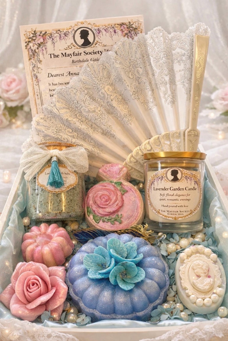 Luxury self care spa gift set with candle, bath salts, bath bombs and handmade soaps arranged in a pastel blue gift box with romantic vintage aesthetic.