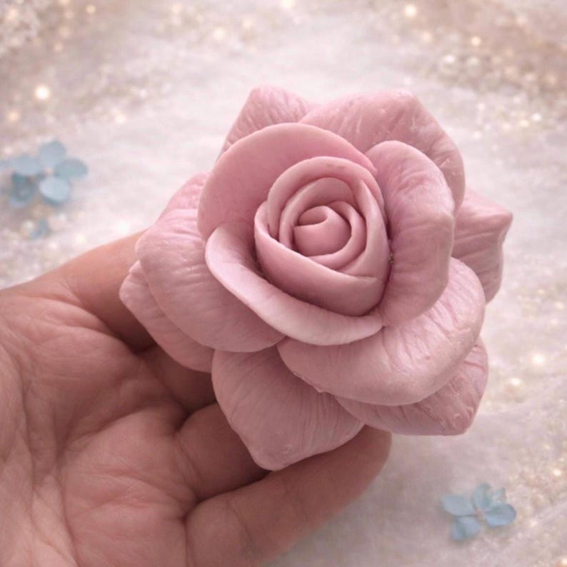 Handcrafted pink rose soap held in hand, delicate floral soap from luxury spa gift box.