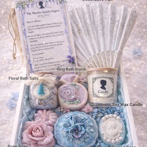 Luxury spa gift box contents including soy candle, bath salts, bath bombs, rose soap, cameo soap and decorative fan.