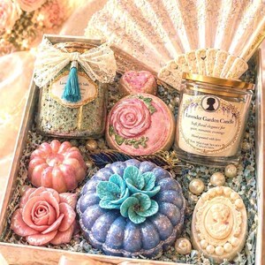 Luxury spa gift box with handmade soaps, bath bombs, lavender bath salts and scented candle, beautifully arranged in an elegant open box with decorative fan and floral details, perfect gift for her