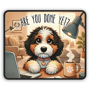 May include: A cartoon dog with brown, black, and white fur sits at a desk with a laptop, a cup of coffee, and a lamp. The dog is looking at the camera with a cute expression. The text "ARE YOU DONE YET?" is written above the dog.