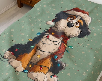May include: A green blanket featuring a cartoon dog wearing a Santa hat and a red scarf, wrapped in Christmas lights. The blanket has a snowflake pattern and is placed on a bed.
