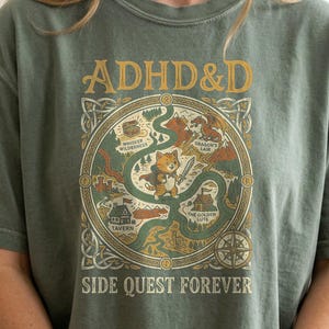 Green t-shirt with "ADHD&D SIDE QUEST FOREVER" text and fantasy game map design.