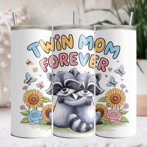 May include: Two white tumblers with a design of two raccoons hugging and the text "Twin Mom Forever" in colorful letters. The raccoons are surrounded by flowers and butterflies.