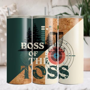May include: Three stainless steel tumblers with a green, wood, and white design. The tumblers feature a disc golf disc, trees, and the text "Boss of the Toss".