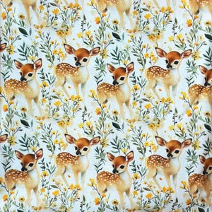 Puede incluir: Patrón repetitivo de cervatillos con manchas blancas, sobre un fondo de flores amarillas y follaje verde. Los ciervos tienen orejas marrones y están sobre un fondo blanco.