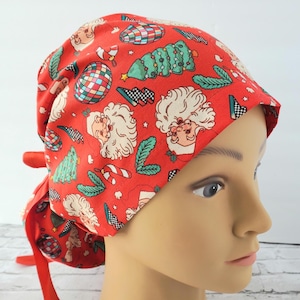 May include: Red surgical scrub hat with a Christmas themed print featuring Santa Claus, Christmas trees, candy canes, and ornaments.