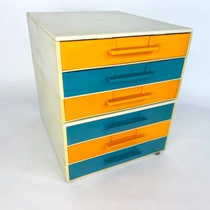 May include: A white ceramic mug with a black handle and the text "But First, Coffee" in a black, bold font. The mug is on a white surface.