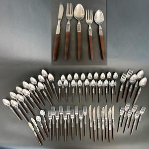 May include: A large flatware set featuring stainless steel heads and dark brown wooden handles. The collection includes various knives, forks, and spoons, with some pieces displaying a decorative metal band between the handle and the utensil head.
