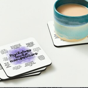 May include: Set of four white square coasters with black borders. Each coaster features a purple watercolor brain with the text "Psychology teacher manifestations" and a list of humorous statements about psychology teachers.