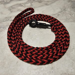 May include: A black and red braided dog leash with a black metal clip.