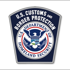May include: A blue and silver patch with the text "U.S. Customs and Border Protection" and the seal of the U.S. Department of Homeland Security.