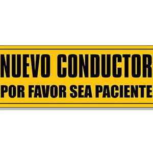May include: A yellow rectangular sign with black text that reads "NUEVO CONDUCTOR POR FAVOR SEA PACIENTE".