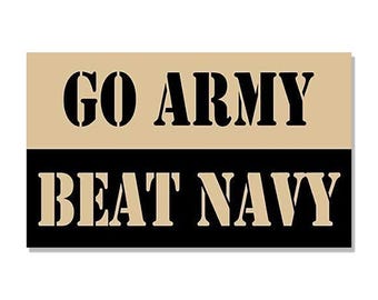 Può includere: Un cartello color beige e nero con il testo "Go Army Beat Navy" in lettere nere.