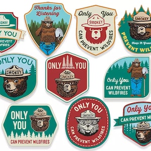 Op de afbeelding: Negen kleurrijke, geïllustreerde patches met Smokey Bear, de mascotte van de U.S. Forest Service, met de tekst "Only You Can Prevent Wildfires".