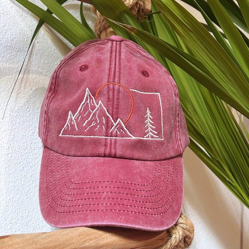 On the left side we have sewn our logo (a stylized orange acorn) on a black background, and inside the label is sewn with the name of the logo.
We embroidered a stylized mountain design with the sun, for those who love adventure, all-around mountains in every season.