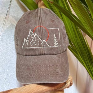 On the left side we have sewn our logo (a stylized orange acorn) on a black background, and inside the label is sewn with the name of the logo.
We embroidered a stylized mountain design with the sun, for those who love adventure, all-around mountains in every season.