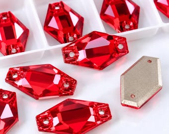 May include: A collection of faceted, diamond-shaped red crystals with two holes for sewing. Each crystal features a brilliant, reflective surface and a flat, metallic-toned backing. The items are arranged both inside a white plastic organizer tray.