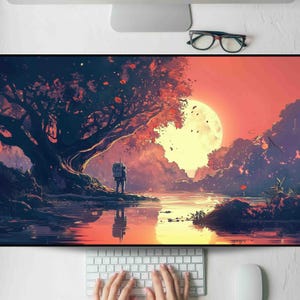 May include: A large rectangular desk mat featuring a digital art landscape. The artwork depicts a figure standing near a body of water, with a large tree and a full moon in the background. The color palette includes shades of orange, red, and purple.