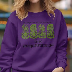 May include: Purple sweatshirt with a green graphic of three Maori tiki faces and the text "he tangata he tangata he tangata tino rangatiratanga".
