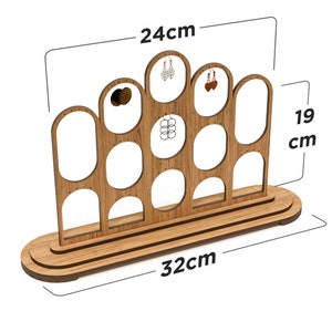 Könnte beinhalten: Holzständer für Ohrringe mit 10 runden Steckplätzen zum Aufbewahren von Ohrringen. Der Ständer ist 24 cm hoch, 32 cm breit und 19 cm tief.