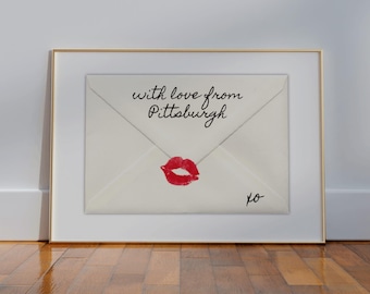Peut inclure: Une enveloppe blanche avec le texte "with love from Pittsburgh" et une marque de rouge à lèvres rouge. L'enveloppe est encadrée d'un cadre doré.